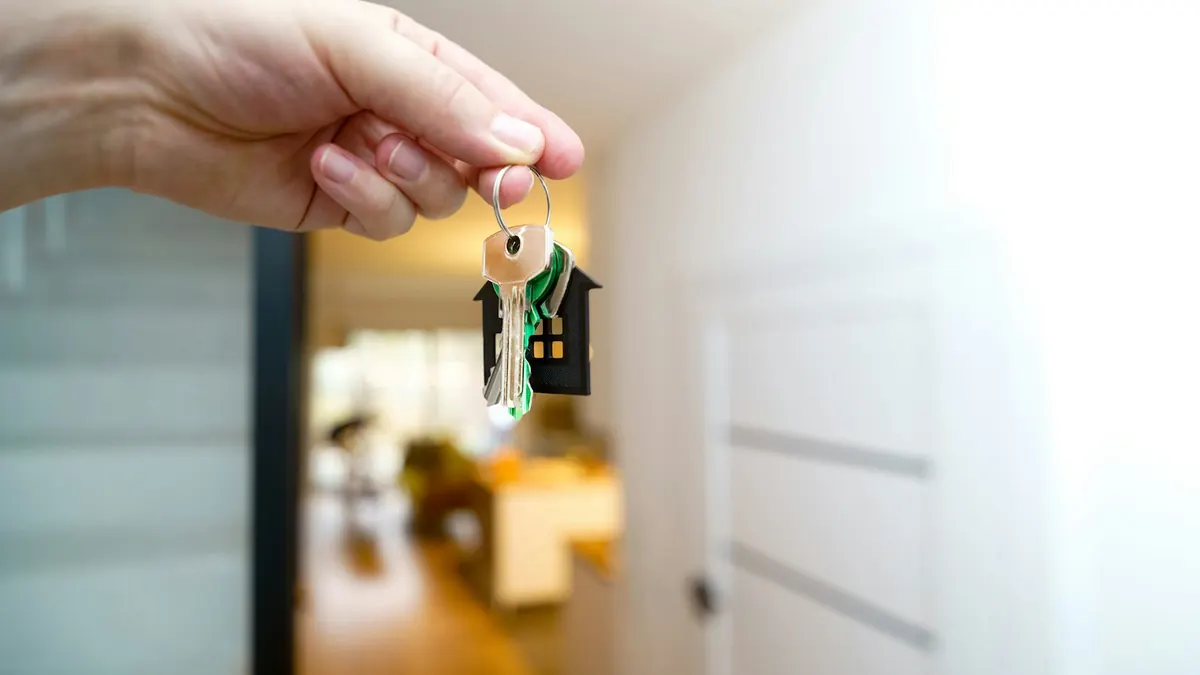Trousseau de clés tenu devant la porte d'un logement, après la souscription d'un nouveau contrat